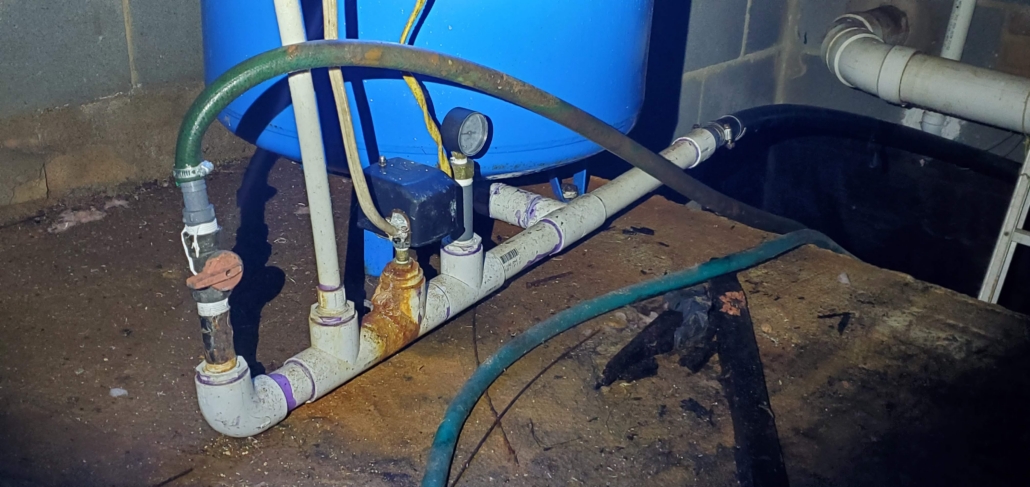 Corroded well pressure tank fittings and piping identified during a well inspection